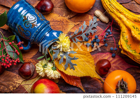 Background. Autumn Decoration Background with chrysanthenum, chestnut, pumpkin, Diospyros kaki, red and blue fruits berry, apple on leaves. Background. Autumn Decoration Background with chrysanthenum, chestnut, pumpkin, Diospyros kaki, red and blue fruits berry, apple on leaves. 111209145