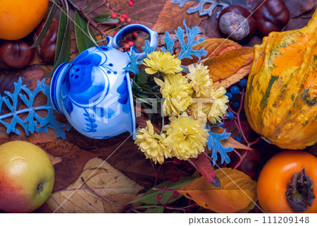 Background. Autumn Decoration Background with chrysanthenum, chestnut, red and blue fruits, small blue jag on leaves. Background. Autumn Decoration Background with chrysanthenum, chestnut, red and blue fruits, small blue jag on leaves. 111209148