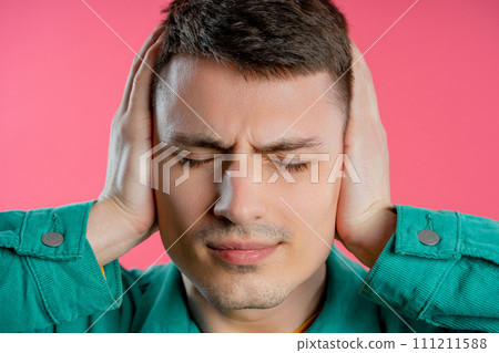 Annoyed man with shut ears on pink background. Guy block annoying sounds Annoyed man with shut ears on pink background. Guy block annoying sounds 111211588
