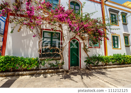 historic center of puerto de mogan with lots of bougainvillea flowers, Canary Island 111212125