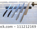sharp kitchen knife on black magnetic holder 111212169