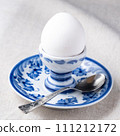 white boiled egg on plate with metal tea-spoon 111212172
