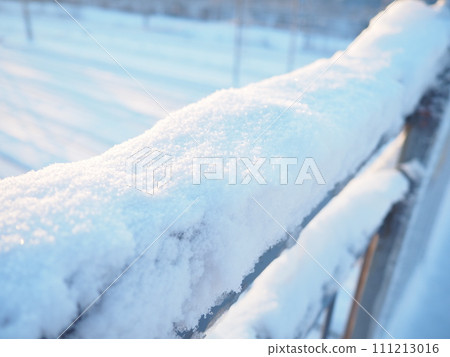Snow, crust and frozen crust on metal railings. Suspension bridge over railway tracks. Harsh arctic climate. Abnormally low air temperatures. Frosty morning. Weather forecast. High snow cover. 111213016