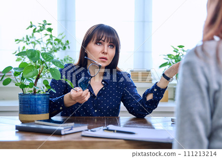 Mature sad woman in therapy session with mental professional 111213214