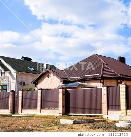 Decorative metal on the roof of a brick house. Fence made of cor Decorative metal on the roof of a brick house. Fence made of cor 111213413