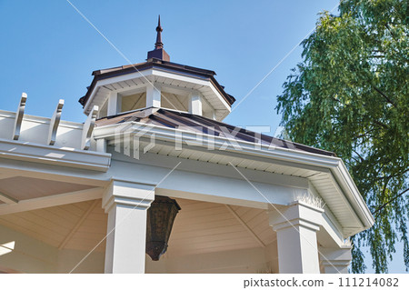 Traditional Home Roof Details and Weathervane Against Blue Sky 111214082