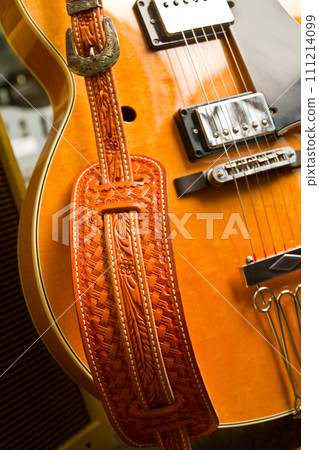 Closeup of Richly Colored Electric Guitar with Intricately Designed Strap 111214099