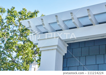 Elegant Suburban Home Roof and Pergola Detail Against Blue Sky Elegant Suburban Home Roof and Pergola Detail Against Blue Sky 111214224