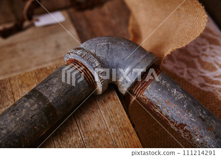 Vintage Pipe Corner on Wooden Surface with Rustic Backdrop 111214291