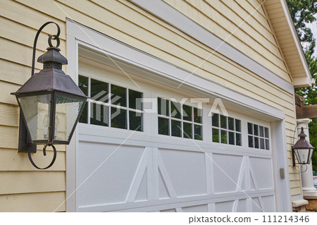 Vintage Lantern and White Garage on Yellow House Facade Vintage Lantern and White Garage on Yellow House Facade 111214346