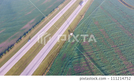 Aerial View of Rural Highway with Green Fields and Wind Turbine Aerial View of Rural Highway with Green Fields and Wind Turbine 111214752