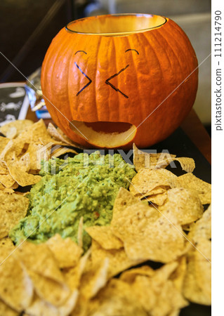 Whimsical Carved Pumpkin with Guacamole and Chips Setup 111214790
