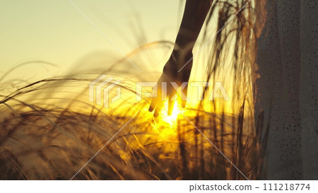 Young woman walks through field after evening yoga to calm body and mind 111218774