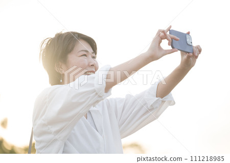 Alafor woman taking a picture of fresh green or taking a selfie 111218985