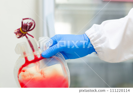 Red Blood bag with blue glove. 111220114