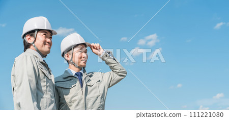 Workers wearing work clothes standing in the blue sky (construction, architecture, design, real estate, civil engineering, construction, site supervision, transportation) Workers wearing work clothes standing in the blue sky (construction, architecture, design, real estate, civil engineering, construction, site supervision, transportation) 111221080