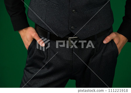 A man's hand in the pocket of gray stylish trousers close-up on a white background. Successful young man, businessman, entrepreneur in an expensive business brown suit, vest A man's hand in the pocket of gray stylish trousers close-up on a white background. Successful young man, businessman, entrepreneur in an expensive business brown suit, vest 111221918