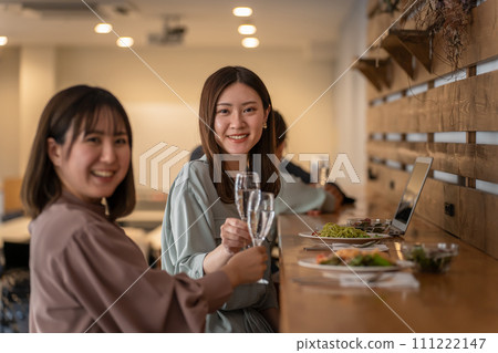 一位女士與朋友/同事在餐廳共進晚餐（香檳/氣泡酒） 111222147