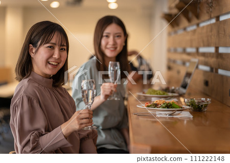 一位女士與朋友/同事在餐廳共進晚餐（香檳/氣泡酒） 111222148