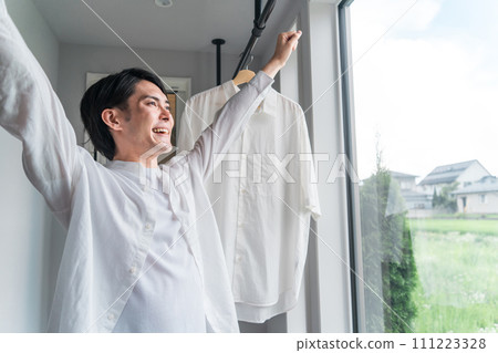 Man drying laundry (housework, househusband, detergent, fabric softener, bleach) Man drying laundry (housework, househusband, detergent, fabric softener, bleach) 111223328