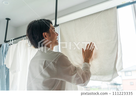 Man drying laundry (housework, househusband, detergent, fabric softener, bleach) Man drying laundry (housework, househusband, detergent, fabric softener, bleach) 111223335