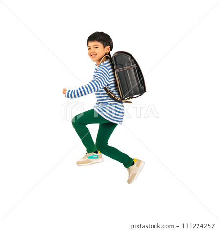 An elementary school boy jumping with a smile while carrying a school bag on his back. Full-body photo PNG with a transparent background precisely cut out by hand. 111224257
