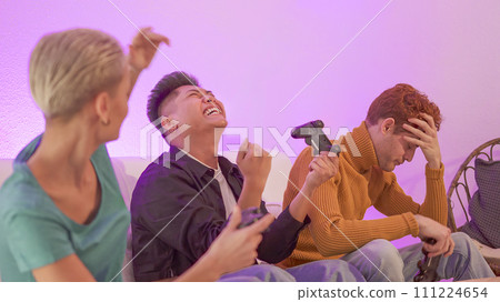 Hispanic man celebrating that wins playing console with friends 111224654