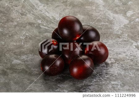 Raw ripe black kumato tomato Raw ripe black kumato tomato 111224996