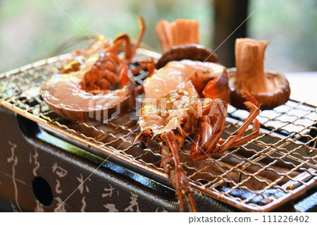 Shrimp grilled over binchotan charcoal and freshly harvested shiitake mushrooms Shrimp grilled over binchotan charcoal and freshly harvested shiitake mushrooms 111226402