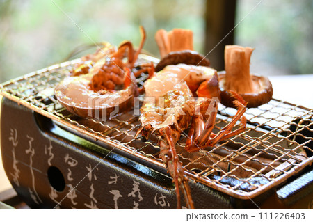 Shrimp grilled over binchotan charcoal and freshly harvested shiitake mushrooms Shrimp grilled over binchotan charcoal and freshly harvested shiitake mushrooms 111226403