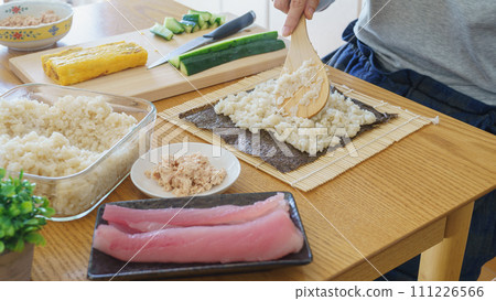 A woman making sushi rolls and seaweed rolls 111226566