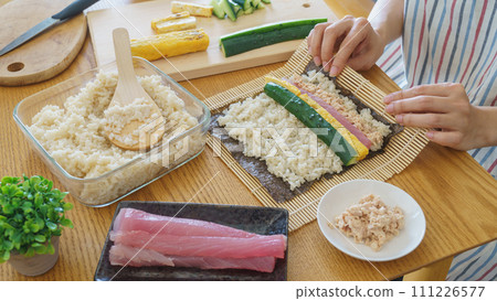 A woman making sushi rolls and seaweed rolls 111226577