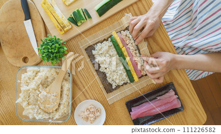 一名婦女製作壽司捲和海藻卷 一名婦女製作壽司捲和海藻卷 111226582