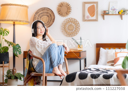 College woman listening to music with headphones 111227038