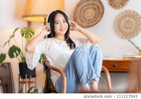 College woman listening to music with headphones College woman listening to music with headphones 111227043