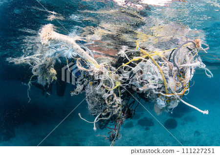 Abandoned fishing net and plastic garbage in the sea 111227251