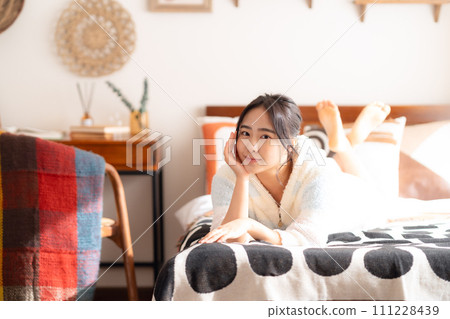 College woman relaxing on bed College woman relaxing on bed 111228439