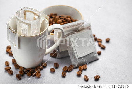 Drip coffee bag with ground coffee in  cup 111228910