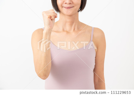 一名穿著吊帶背心的中年婦女正在打拳頭 一名穿著吊帶背心的中年婦女正在打拳頭 111229653