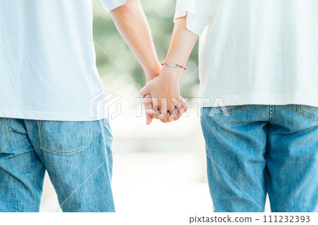 A man and a woman wearing matching jeans holding hands A man and a woman wearing matching jeans holding hands 111232393