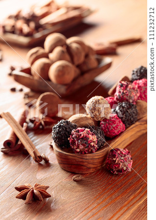 Chocolate truffles on a wooden table. 111232712