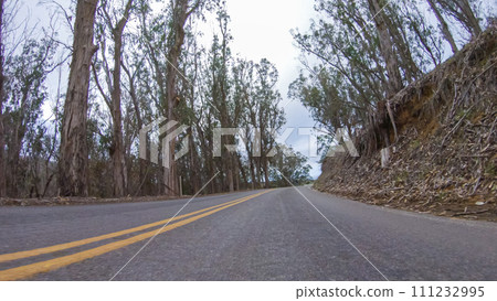 In this serene winter scene, a vehicle carefully makes its way along Los Osos Valley Road and Pecho Valley Road within Montana de Oro State Park. In this serene winter scene, a vehicle carefully makes its way along Los Osos Valley Road and Pecho Valley Road within Montana de Oro State Park. 111232995