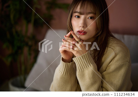 棕色頭髮的女人坐在房間的沙發上 111234634