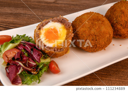 RECIPE FOR BREADED BEEF MEATBALLS STUFFED WITH A SOFT BOILED EGG 111234889