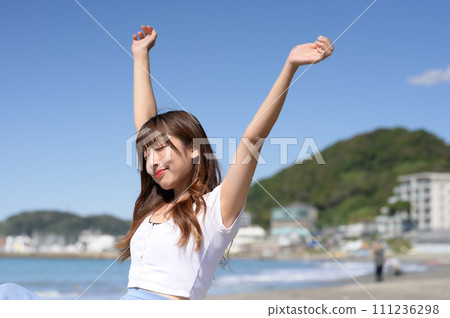 A woman standing on a sandy beach on a sunny day A woman standing on a sandy beach on a sunny day 111236298