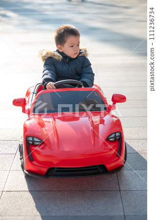 Adventurous Toddler Drives Red Sports Car with Joyful Glee 111236734