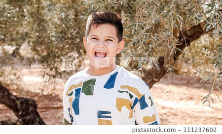 Young boy happy at the camera in the middle of a field 111237602