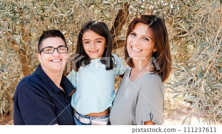 Lesbian couple with their daughter in a rural landscape Lesbian couple with their daughter in a rural landscape 111237611