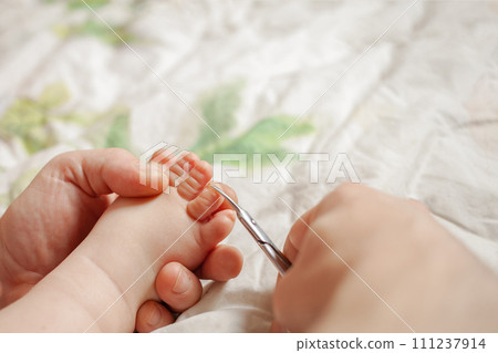A man cuts her nails child hygiene. men's hands hold nail scissors A man cuts her nails child hygiene. men's hands hold nail scissors 111237914