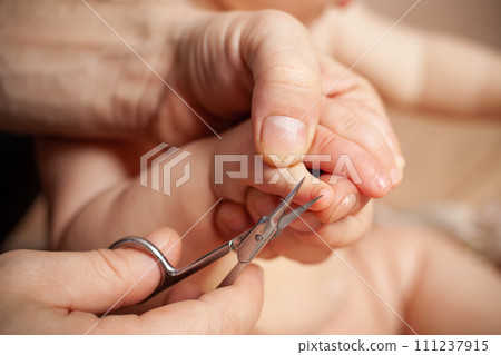 A man cuts her nails child hygiene. men's hands hold nail scissors 111237915